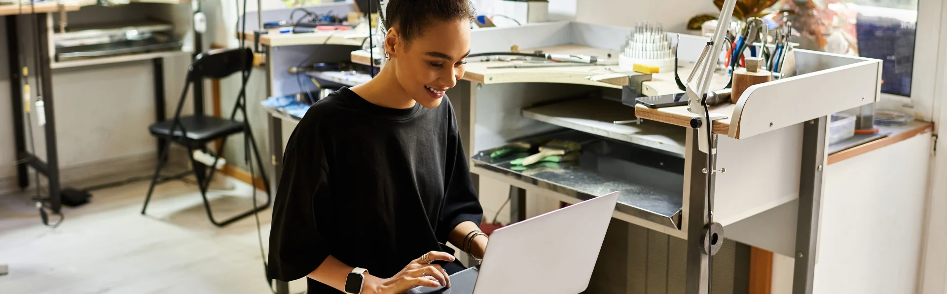 Handwerkerin am Laptop in der Werkstatt